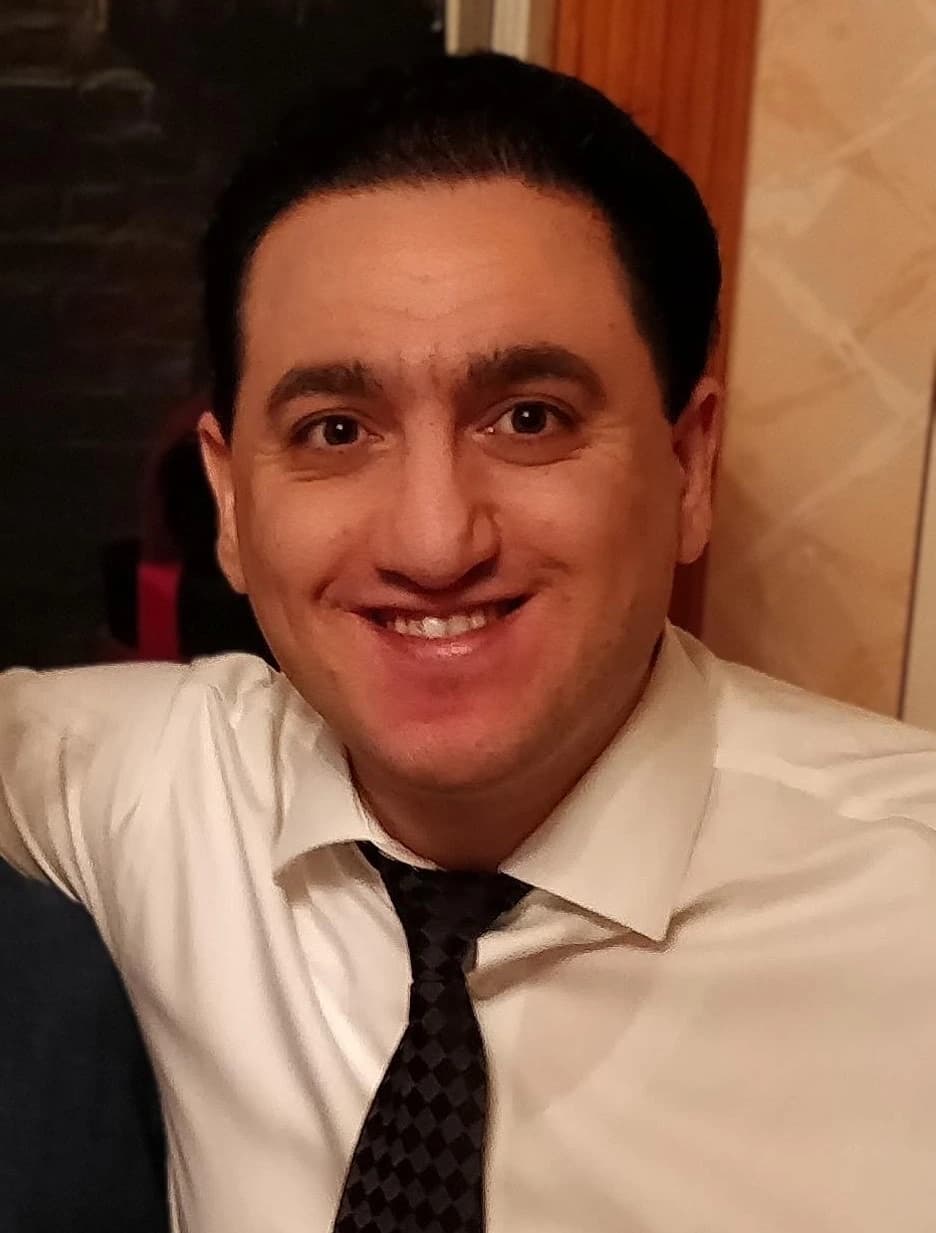 Portrait photograph of Dmitriy Malayev smiling at the camera.